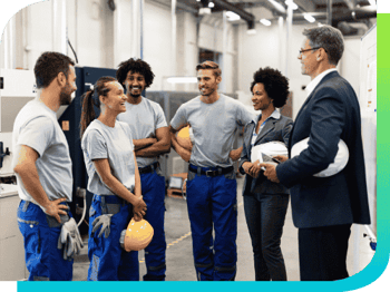 executives meeting employees on factory floor